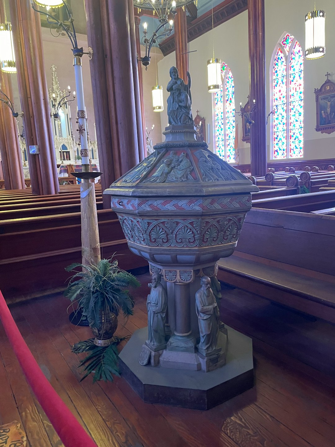 Une piscine baptismale ornée en pierre sculptée à l'intérieur d'une église traditionnelle.